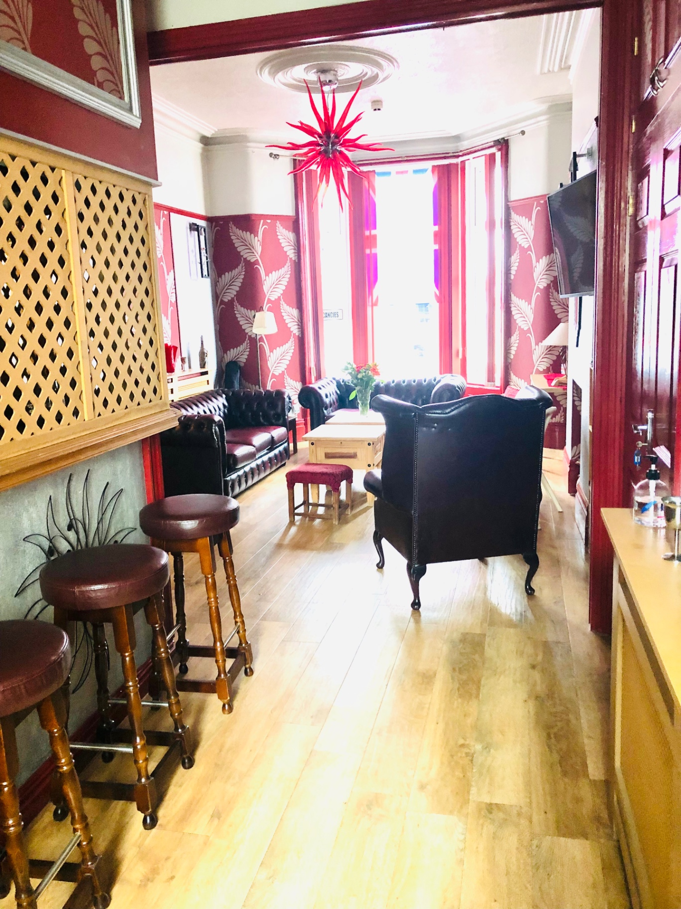 Guest lounge with Chesterfield sofas and patterned wallpaper